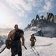 Kratos and Atreus walk on a snowy mountaintop in God of War on PS4 playing on a PS5.